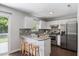 Bright kitchen with stainless steel appliances, mosaic backsplash, and breakfast bar at 4708 River Boat Landing Ct, Raleigh, NC 27604