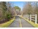 Asphalt path featuring a yellow center line and white fence leading to an unknown destination at 4708 River Boat Landing Ct, Raleigh, NC 27604