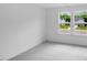 A comfortable, carpeted bedroom space with white walls and two windows showing a pleasant neighborhood at 630 Contento Ct, Sanford, NC 27330