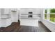 Bright white kitchen features a central island with granite countertops, stainless steel appliances, and hardwood floors at 630 Contento Ct, Sanford, NC 27330