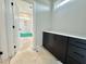 Bathroom featuring modern black vanity and a glimpse into a tiled shower/tub at 130 Broadleaf Ln, Louisburg, NC 27549