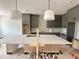 Spacious kitchen features modern gray cabinets, a large quartz island, and pendant lighting at 130 Broadleaf Ln, Louisburg, NC 27549