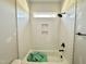 Bright bathroom featuring a shower-tub combo with white, herringbone tiling and sleek black hardware at 130 Broadleaf Ln, Youngsville, NC 27596