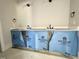 Bathroom featuring double sinks, modern hardware, and under-cabinet storage at 130 Broadleaf Ln, Youngsville, NC 27596