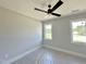 Bedroom featuring a modern ceiling fan, two white-framed windows and light-colored walls and carpet at 130 Broadleaf Ln, Youngsville, NC 27596