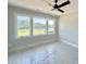 A bright bedroom with three white-framed windows lined across the back wall providing a scenic view at 130 Broadleaf Ln, Youngsville, NC 27596