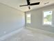 Bedroom featuring neutral paint, white trim, two windows, and a ceiling fan at 130 Broadleaf Ln, Youngsville, NC 27596