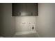 Laundry room with neutral paint and built-in overhead storage cabinets at 130 Broadleaf Ln, Youngsville, NC 27596