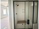 Modern shower with black hardware, including a shower head and handle, with white tile and a glass door at 130 Broadleaf Ln, Youngsville, NC 27596