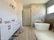Elegant primary bathroom with double vanities, soaking tub, tiled shower, and modern finishes at 135 Cherry Bark Dr, Youngsville, NC 27596