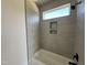 Stylish bathroom featuring tub with tiled walls and built-in shower niche at 135 Cherry Bark Dr, Youngsville, NC 27596