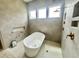 Modern bathroom features a freestanding tub, a rain shower head, and sleek tile work at 135 Cherry Bark Dr, Youngsville, NC 27596
