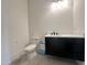 Modern bathroom includes a sleek vanity with a black faucet, a toilet, and neutral tile flooring at 135 Cherry Bark Dr, Youngsville, NC 27596