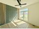 Bright bedroom featuring a unique green accent wall and a modern ceiling fan at 135 Cherry Bark Dr, Youngsville, NC 27596