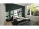 Bedroom featuring an accent wall with geometric paneling, large windows, and stylish decor at 135 Cherry Bark Dr, Youngsville, NC 27596