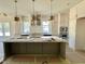 Bright, spacious kitchen with a large island, stainless appliances, custom cabinets, and modern pendant lighting at 135 Cherry Bark Dr, Youngsville, NC 27596