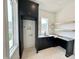 A functional laundry room features custom black cabinets, sink, and built-in shelves for convenience at 135 Cherry Bark Dr, Youngsville, NC 27596