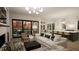 Bright, open-concept living room with modern lighting and floor-to-ceiling sliding glass doors showcasing backyard at 135 Cherry Bark Dr, Youngsville, NC 27596