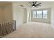Spacious unfinished loft area with natural light from large windows and modern black railing at 135 Cherry Bark Dr, Youngsville, NC 27596