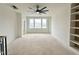 Unfinished loft with three windows, ceiling fan and view of neighborhood with built-in shelves on the right at 135 Cherry Bark Dr, Youngsville, NC 27596