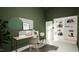 Stylish home office with green walls, a modern desk, chair, and a white shelving unit filled with books at 135 Cherry Bark Dr, Youngsville, NC 27596
