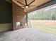 Spacious outdoor patio features a brick fireplace, ceiling fan, and serene view of the backyard at 135 Cherry Bark Dr, Youngsville, NC 27596