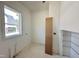 A versatile room with a large window and fresh white walls, ready for customization as an office or den at 135 Cherry Bark Dr, Youngsville, NC 27596