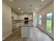 Contemporary kitchen boasts white cabinetry, granite countertops, stainless sink in island, black appliances, and wood flooring at 163 Vili Dr, Broadway, NC 27505