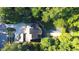Stunning aerial view of a multi-level home surrounded by lush greenery with a fire pit and deck areas at 2213 Weybridge Dr, Raleigh, NC 27615