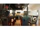 Detailed wet bar with a wine cooler, dark wood, shelving, seating, and bar sink at 2213 Weybridge Dr, Raleigh, NC 27615