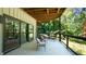 Large covered deck with sliding doors, furniture, and wood floors, offering a peaceful outdoor space at 2213 Weybridge Dr, Raleigh, NC 27615