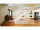 Spacious foyer with white staircase, hardwood floors, and a glimpse into the living area creating a welcoming and bright entryway at 2213 Weybridge Dr, Raleigh, NC 27615