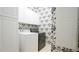 Functional laundry room with washer, dryer, storage cabinets, and decorative wallpaper at 2213 Weybridge Dr, Raleigh, NC 27615