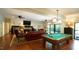 Open living area with fireplace, billiard table, ceiling fans, hardwood floors, and sliding glass doors at 2213 Weybridge Dr, Raleigh, NC 27615