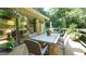 Outdoor dining area on a wood deck with an umbrella and lush greenery at 2213 Weybridge Dr, Raleigh, NC 27615