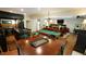Open living space with a wet bar, pool table, dining area, and a cozy fireplace at 2213 Weybridge Dr, Raleigh, NC 27615
