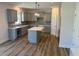 Stylish kitchen with gray cabinets, granite countertops, a kitchen island, and stainless steel appliances at 23 Surles Landing Way, Benson, NC 27504