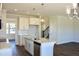 Kitchen features white cabinets, granite countertops, stainless steel appliances, island, and wood floors at 48 Surles Landing Way, Benson, NC 27504