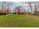 A spacious, green backyard features mature trees and a playset near the brick home at 5205 Rembert Dr, Raleigh, NC 27612