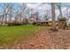 A spacious, green backyard features mature trees and a playset near the brick home at 5205 Rembert Dr, Raleigh, NC 27612