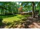 Expansive backyard featuring a well-maintained lawn, mature trees, and a charming play structure at 5205 Rembert Dr, Raleigh, NC 27612