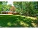 Spacious backyard perfect for outdoor activities and relaxation, with a mature tree and playset at 5205 Rembert Dr, Raleigh, NC 27612