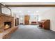 Finished basement offers a brick fireplace, carpeted floor, and natural light from windows at 5205 Rembert Dr, Raleigh, NC 27612