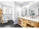Bathroom featuring dual sink vanity, modern fixtures, a window, and black tiled flooring at 5205 Rembert Dr, Raleigh, NC 27612