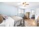 Comfortable bedroom showcasing light blue walls, hardwood floors, and a window with natural light at 5205 Rembert Dr, Raleigh, NC 27612