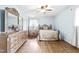 Cozy bedroom featuring light blue walls, hardwood floors, and a large wooden dresser with mirror at 5205 Rembert Dr, Raleigh, NC 27612