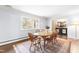 Dining area with a table, six chairs, hardwood floors, a large window, and access to the foyer at 5205 Rembert Dr, Raleigh, NC 27612