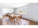 Bright dining room with hardwood floors, a large window, and elegant wood table at 5205 Rembert Dr, Raleigh, NC 27612