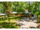 Lovely single-Gathering home with lush landscaping, a driveway, and mature trees creating curb appeal at 5205 Rembert Dr, Raleigh, NC 27612