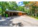 Brick home featuring a carport, ample parking, and an inviting outdoor patio area for gatherings at 5205 Rembert Dr, Raleigh, NC 27612